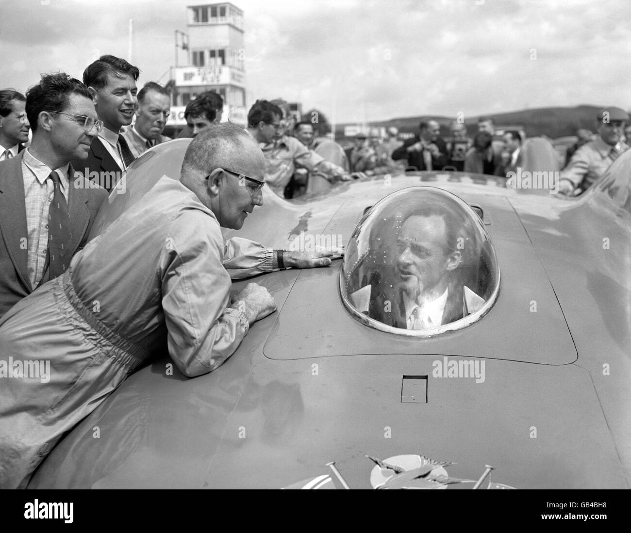 (G-D) l'ingénieur Leo Villa parle à Donald Campbell, assis au volant de sa voiture Bluebird. Banque D'Images