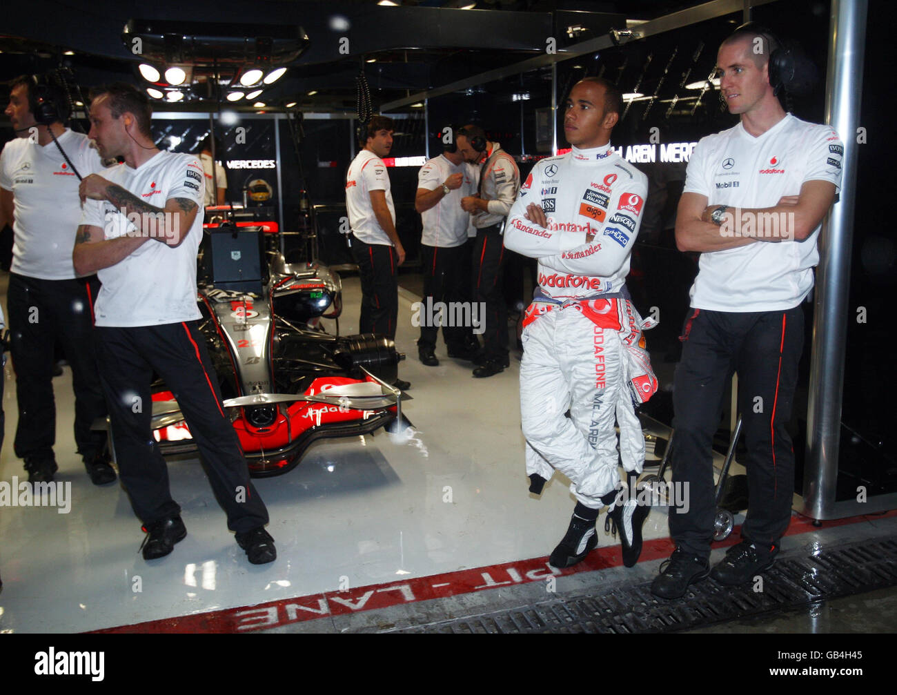 Lewis Hamilton, en Grande-Bretagne, observe la pluie de l'avant du garage pendant une séance d'entraînement à Monza, en Italie. Banque D'Images