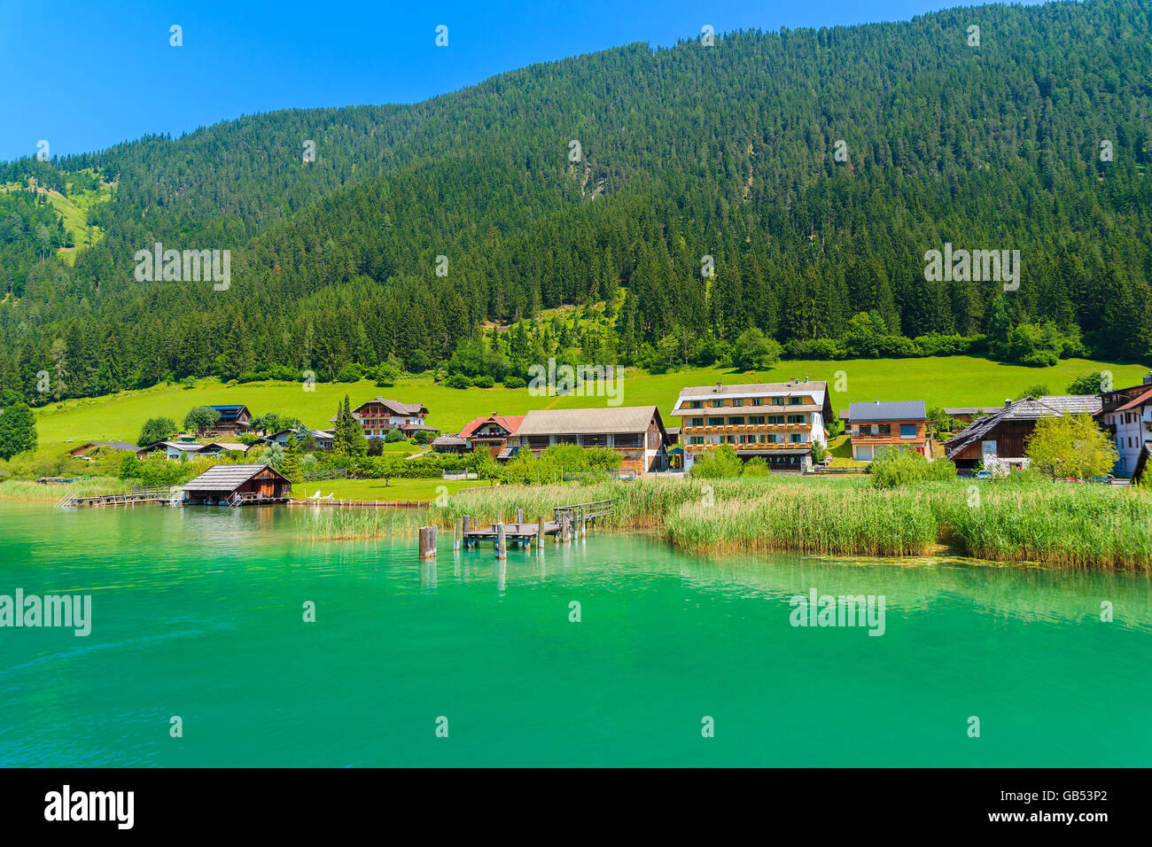 Maisons sur les rives du magnifique lac alpin Weissensee en été paysage de montagnes des Alpes, Autriche Banque D'Images