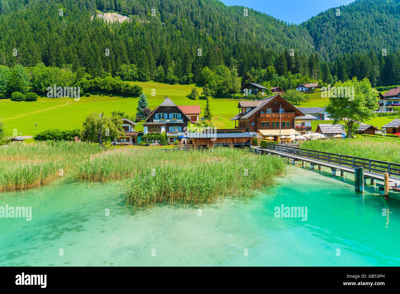Maisons sur les rives du magnifique lac alpin Weissensee en été paysage de montagnes des Alpes, Autriche Banque D'Images