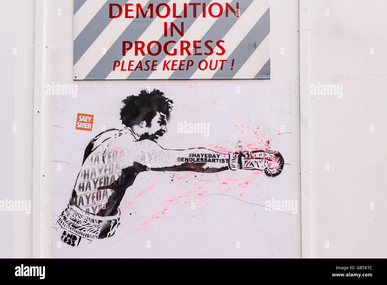 Graffiti dans un chantier avec le boxeur David Haye avec un poing frappe horizontale ci-dessous une affiche disant Démolition en cours Banque D'Images