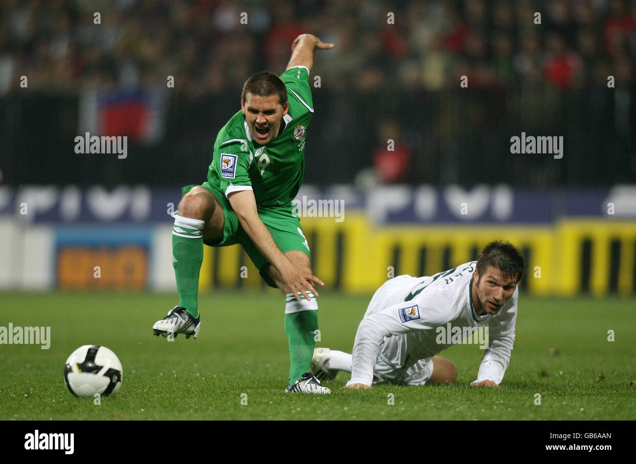 David Healy, en Irlande du Nord, est fouillé par Bostjan Cesar, en Slovénie, lors du match du groupe de qualification de la coupe du monde au stade Ljudski Vrt, à Maribor, Solvenia. Banque D'Images