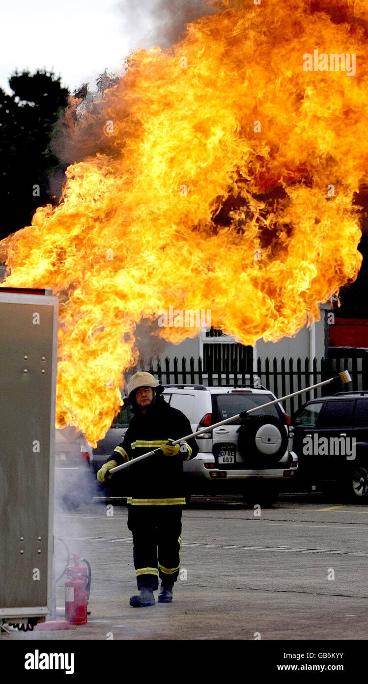 Le pompier Jim O'Brian démontre les dangers de verser de l'eau sur un feu de poêle à copeaux lors du lancement de la semaine de la sécurité incendie, au centre d'entraînement de la brigade des pompiers à Dublin. Banque D'Images