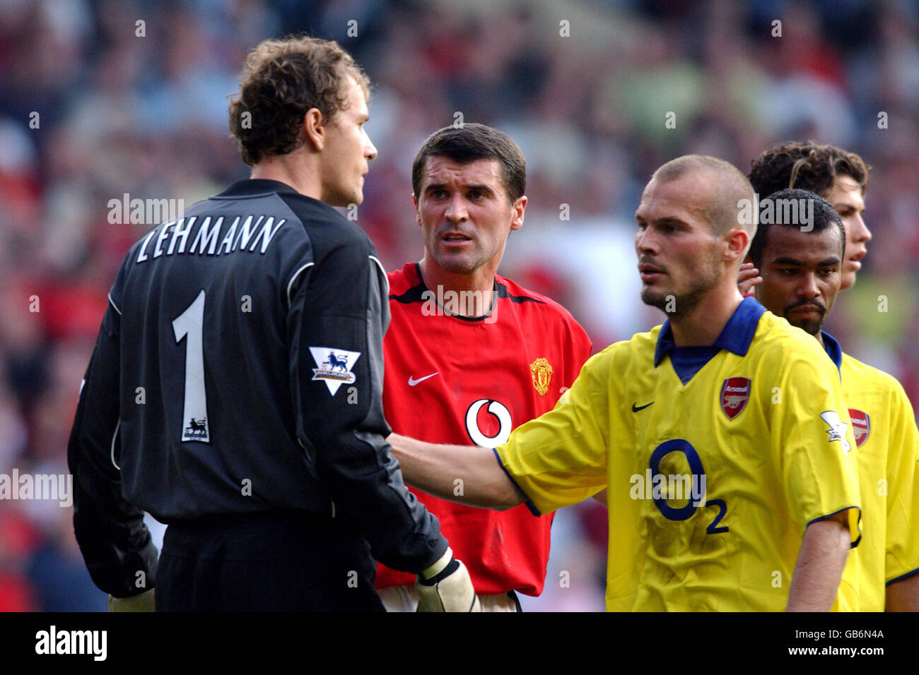 Le gardien de but d'Arsenal Jens Lehmann (l) est calmé par un coéquipier Fredrik Ljungberg et le capitaine Roy Keane de Manchester United Banque D'Images