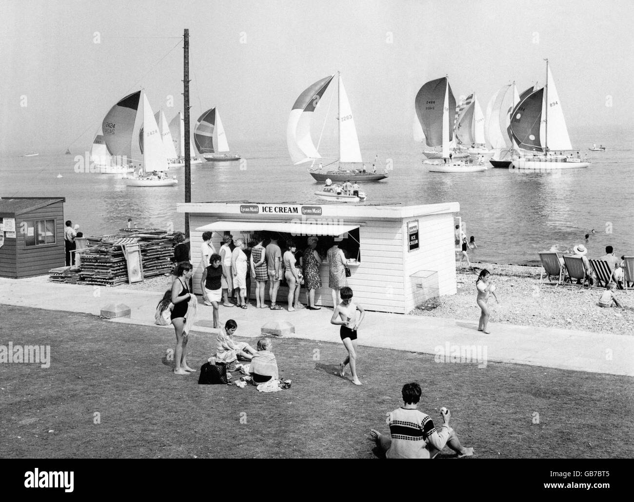 Temps d'été - vacances britanniques - la mer - Cowes - 1970.Les vacanciers ont la queue pour acheter de la crème glacée lors d'une chaude journée d'été à Cowes sur l'île de Wight. Banque D'Images