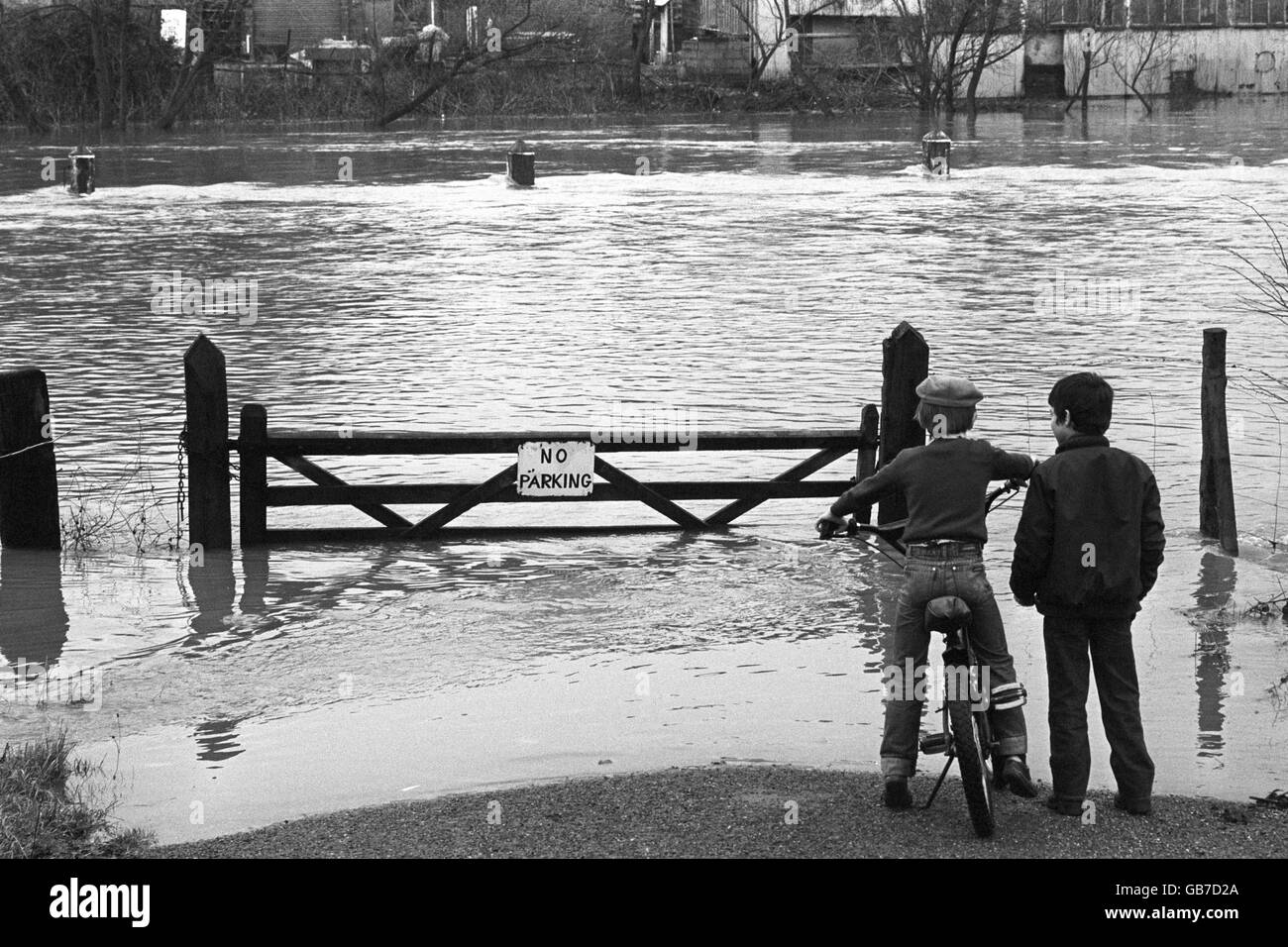 L'inondation de la rivière Severn à Gloucester est surveillée par deux petits garçons. Banque D'Images