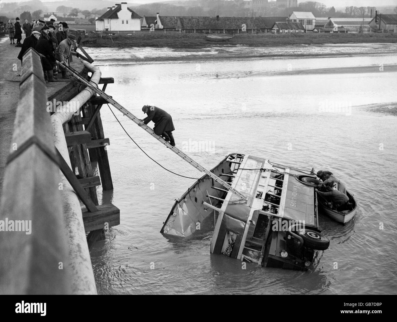 Les travailleurs clamberaient sur le bus à impériale qui a été balayé par un pont dans une rivière à 20 pieds en dessous. 25 personnes ont été piégées dans le bus qui relie Worthing à Brighton. Le fait que la marée ait été basse a sauvé les passagers de la noyade. Banque D'Images