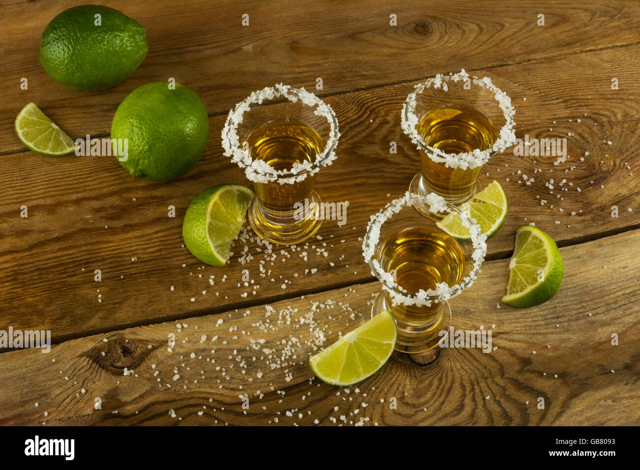 Tequila shots avec de la chaux et du sel sur le fond de bois, vue du dessus. La Tequila. Gold tequila mexicaine. Tequila shot Banque D'Images