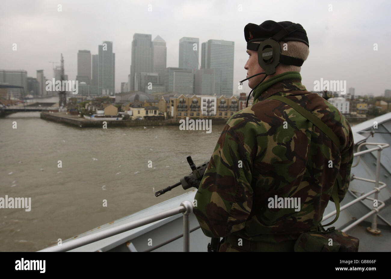 Un marin de la Royal Navy se tient sur le pont du porte-avions HMS illustre alors qu'il se tourne devant Canary Wharf avant de s'amarrer à Greenwich, au début d'une visite de neuf jours à Londres. Banque D'Images