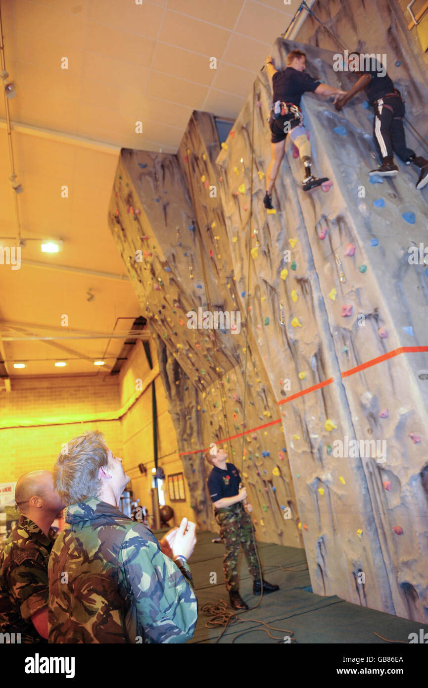 Le prince Harry regarde Ben McBean, qui a perdu un bras et une jambe au combat, monter un mur au lancement du Khumbu Challenge 09 à HM Devonport à Plymouth. Banque D'Images