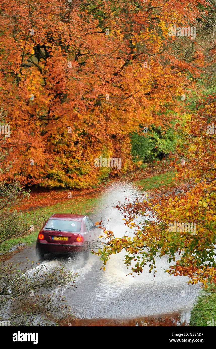 Une voiture traverse les eaux de crue à Brampton, près de Carlisle, à Cumbria, après que la pluie de près d'un mois soit tombée en une journée dans certaines parties du comté et que des dégringoins torrentiels ont bloqué plusieurs routes. Banque D'Images