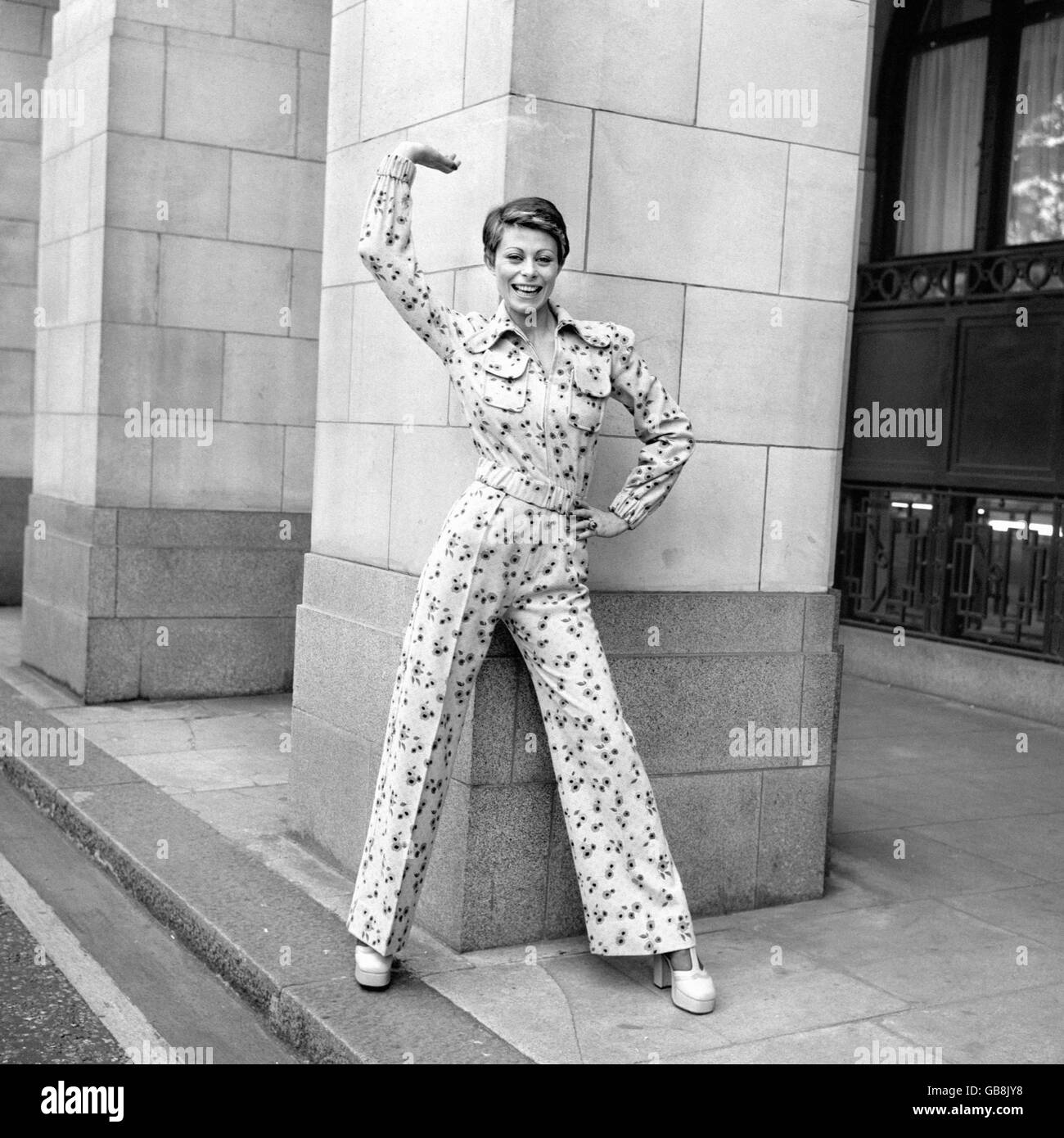 Anne Goddet, porte le costume à pantalon « Smiler Sam » de Mary Quant, en flanelle imprimée rose et jaune sur fond bleu pâle. Banque D'Images