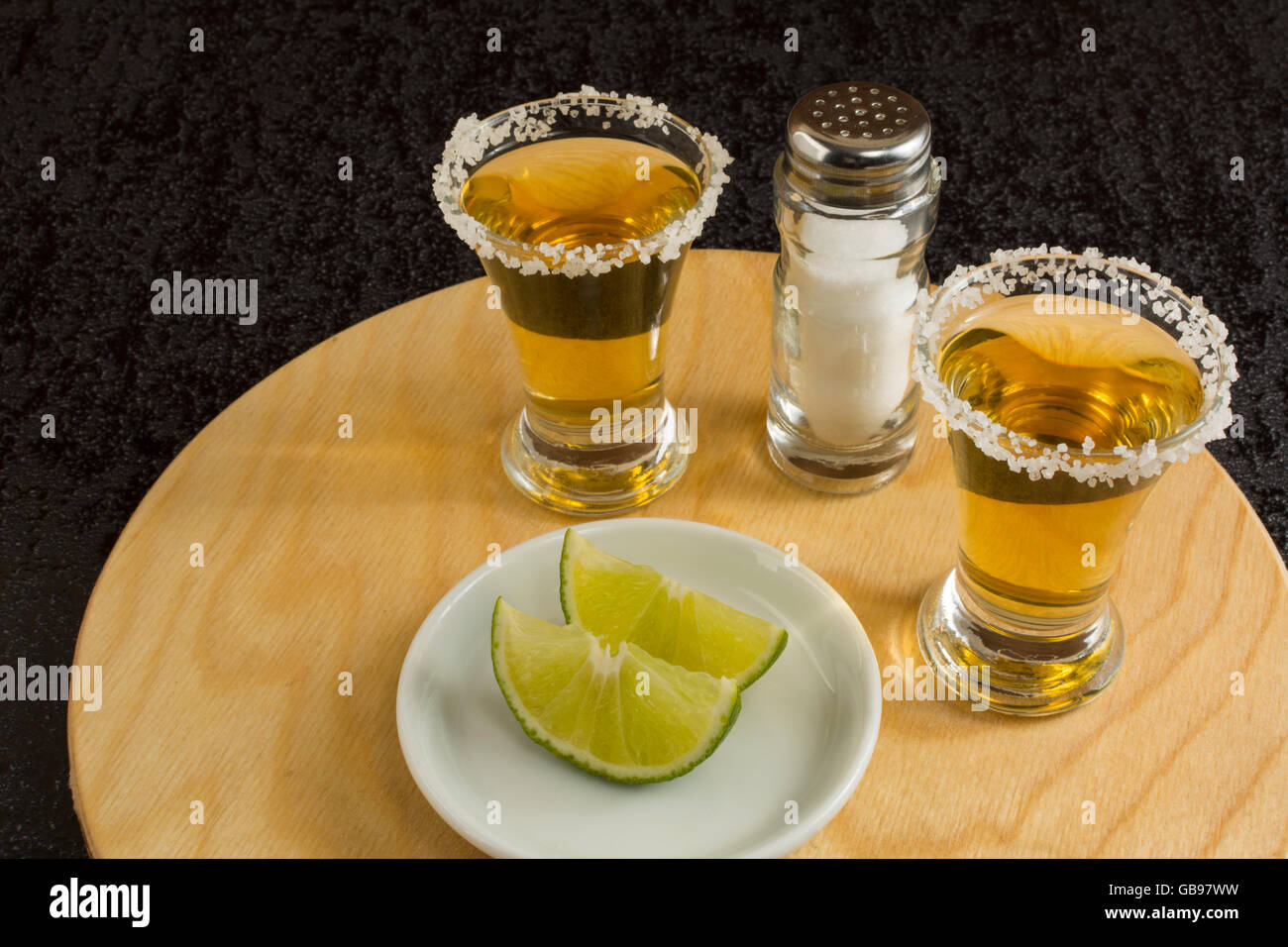 Coups de Fuissé avec de la chaux et du sel sur le bois rond. Shot de tequila. Gold tequila mexicaine. Tequila Banque D'Images