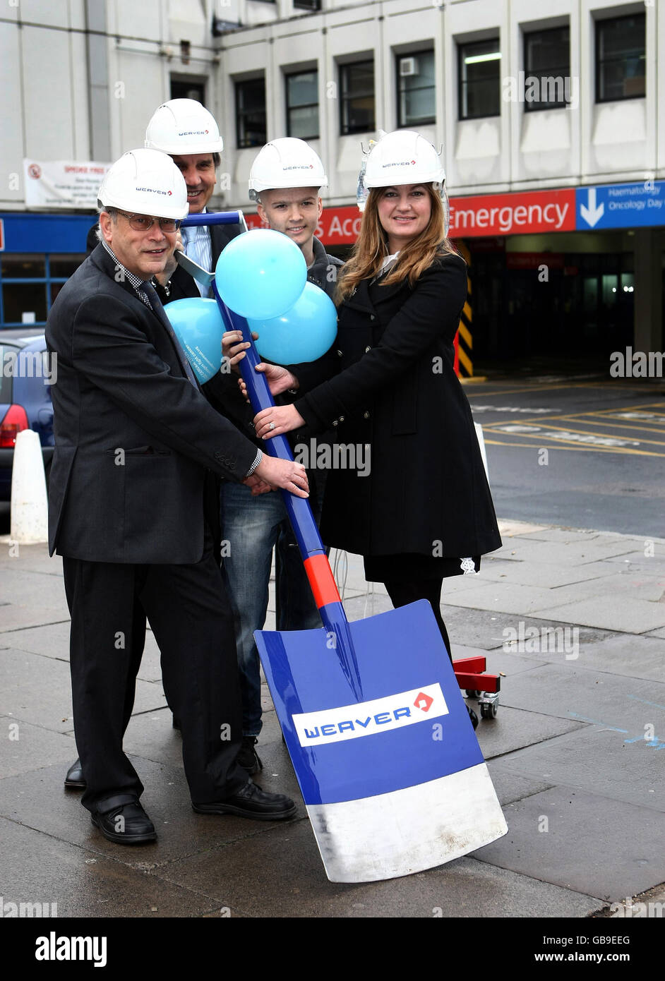 De gauche à droite. Matthew Engel du Laurie Engel Fund, Simon Davies du Teenage cancer Trust, de la victime de cancer Tyler Bradley, 15 ans, de Stourbridge et du directeur d'entreprise du sport Karren Brady lors de la cérémonie de découpe du gazon pour le nouveau bâtiment du Teenage cancer Trust à l'hôpital pour enfants de Birmingham. Banque D'Images