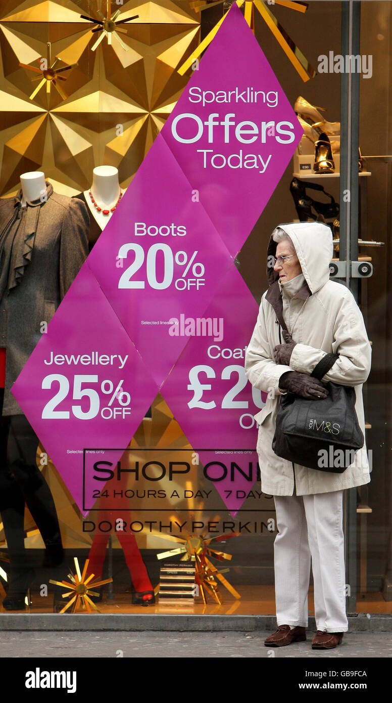 Un client mystère se trouve près d'une enseigne de vente dans la fenêtre d'une succursale de Dorothy Perkins à Oxford Street, Londres. Banque D'Images