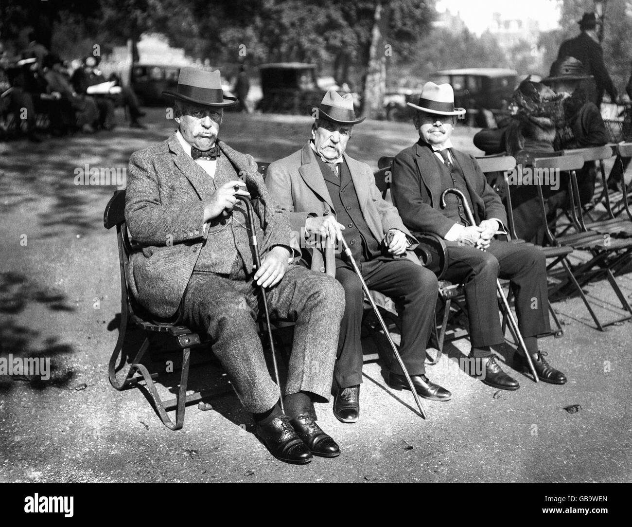 Lord Fitzwarine Chichester (centre) et Charles Thornton, le célèbre ancien cricketer (l) se détendant lors d'une journée ensoleillée dans le parc. Banque D'Images