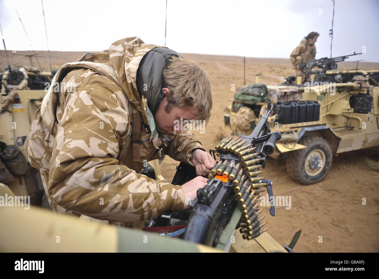 James Sudlow, 22 ans, de l'Owestry St. Martins, de la 1re, les Queens Dragoon Guards nettoient et maintiennent un pistolet à machine à usage général (GPMG) après une pluie torrentielle la nuit précédente, dans la province de Helmand, en Afghanistan. Banque D'Images