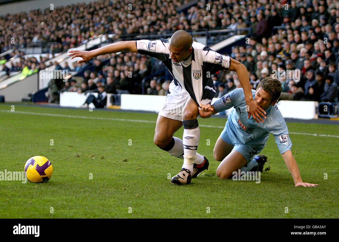 Le Gianni Zuiverloon (l) de West Bromwich Albion est encrassé par Tottenham David Bentley de Hotspur, alors qu'ils se battent pour le ballon Banque D'Images