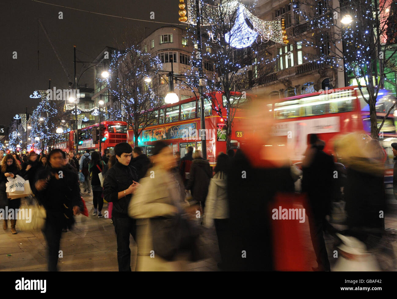 Les amateurs de shopping sur Oxford Street à Londres sont à la recherche de bonnes affaires de Noël de dernière minute ce soir. Banque D'Images