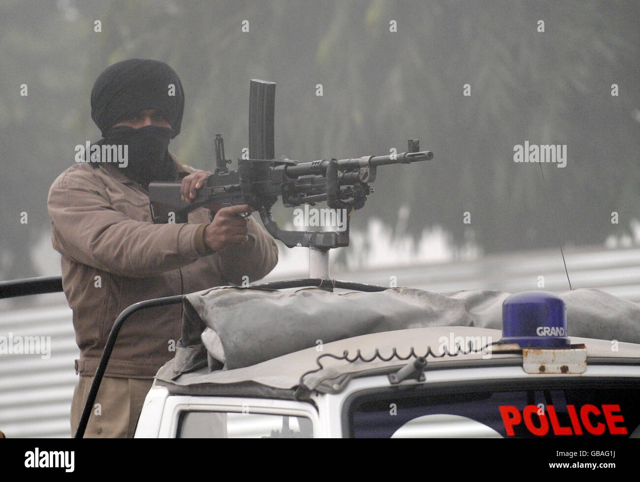 Des forces de police armées à l'extérieur du sol, comme de gros retards dans le brouillard, jouent avant le cinquième jour du deuxième test au stade de l'Association de cricket du Punjab, à Mohali, en Inde. Banque D'Images