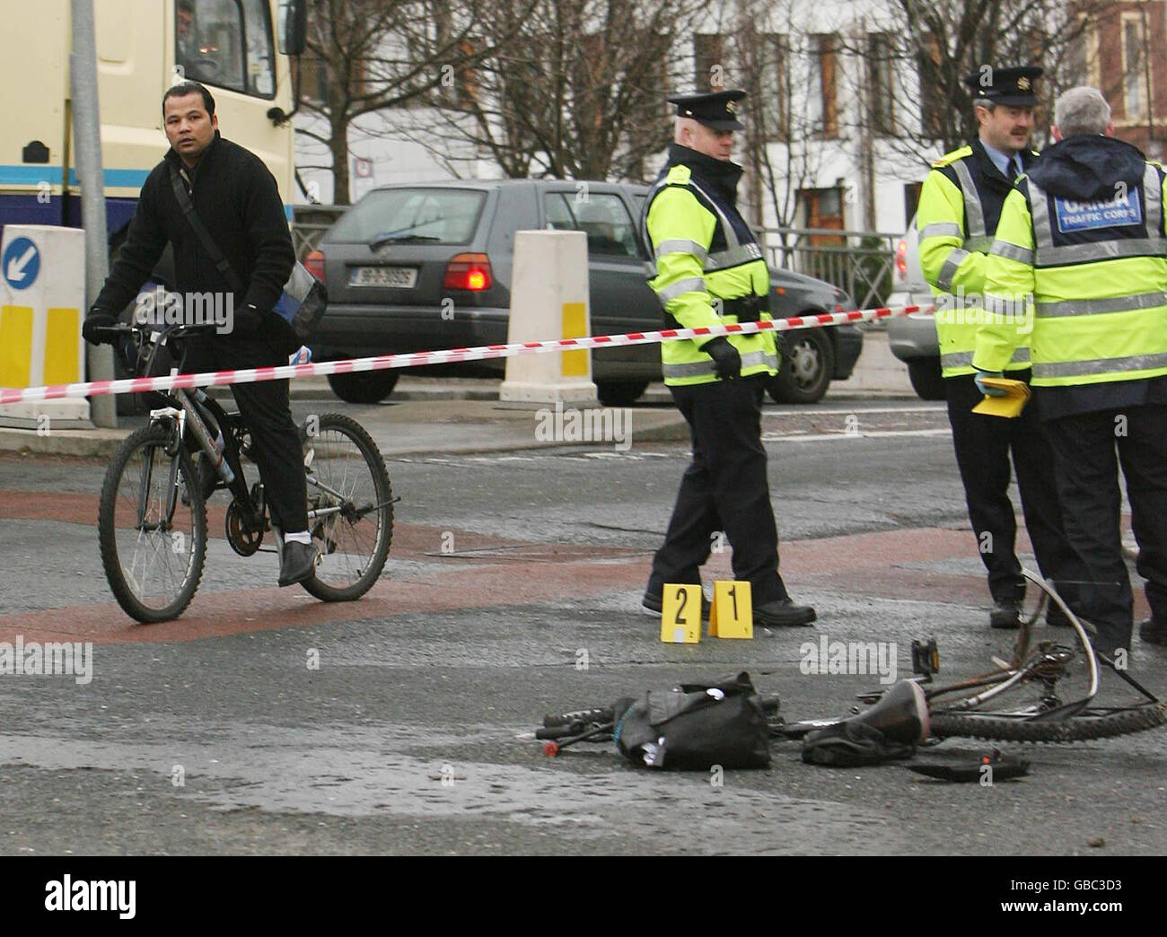 Un cycliste passe devant la scène où un autre cycliste a été tué ce matin dans un accident de la route dans la région de Harolds Cross Road à Dublin. Banque D'Images