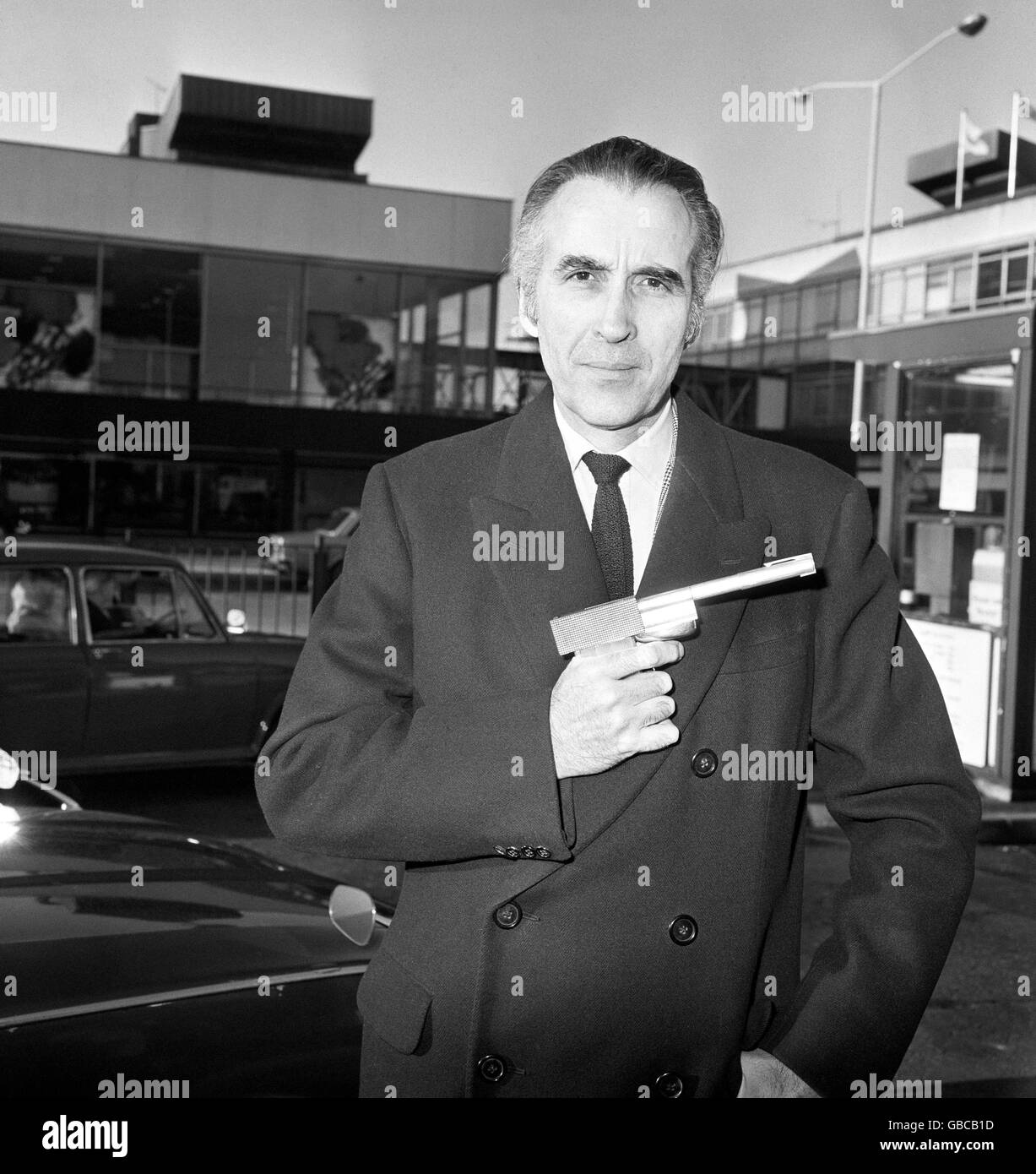 Acteur Christopher Lee avec le canon d'or, il joue Scaramanga dans le film James Bond.Il est arrivé de New York avec le pistolet de nouveauté utilisé dans la partie du méchant écoboyish. Banque D'Images