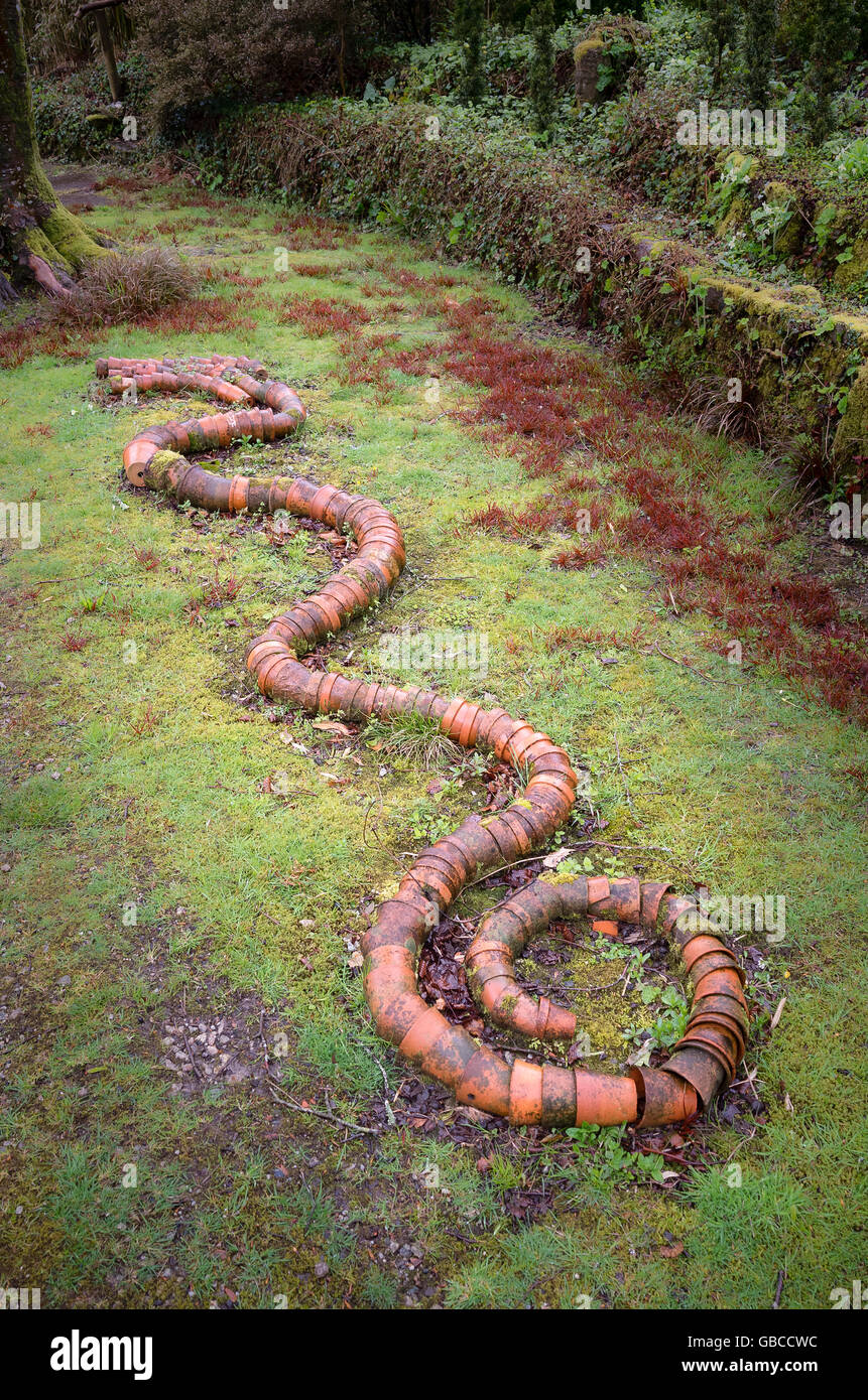 Dans le jardin de l'oeuvre comprenant des pots en terre cuite s'est joint à ressembler à un serpent tortillant Banque D'Images Dans le jardin de l'oeuvre comprenant des pots en terre cuite s'est joint à ressembler à un serpent tortillant Banque D'Images