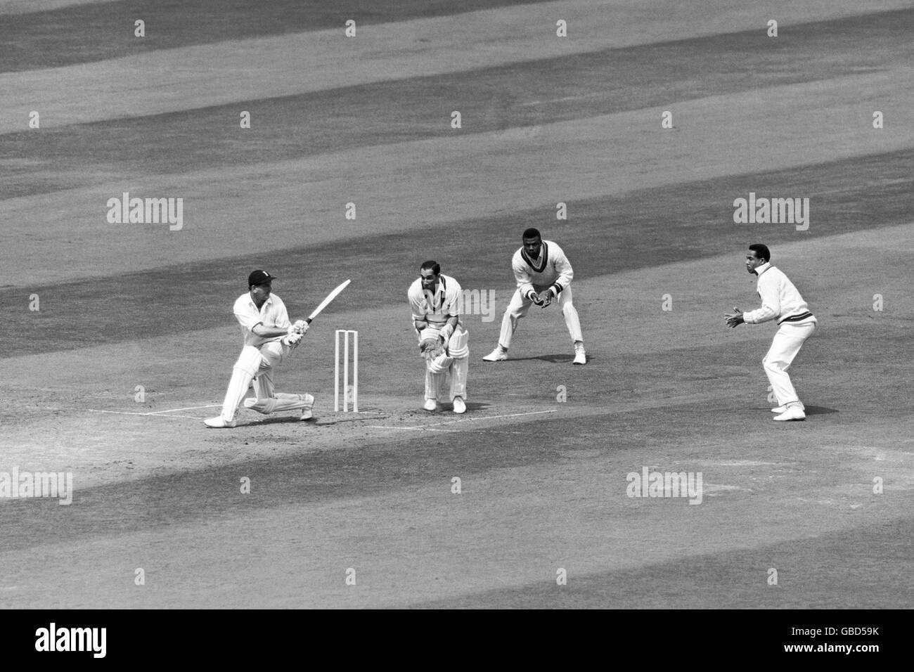 (G-D) Tom Graveney, en Angleterre, tente de balayer le ballon devant David Allan, Seymour Nurse et Gary Sobers, des Antilles Banque D'Images