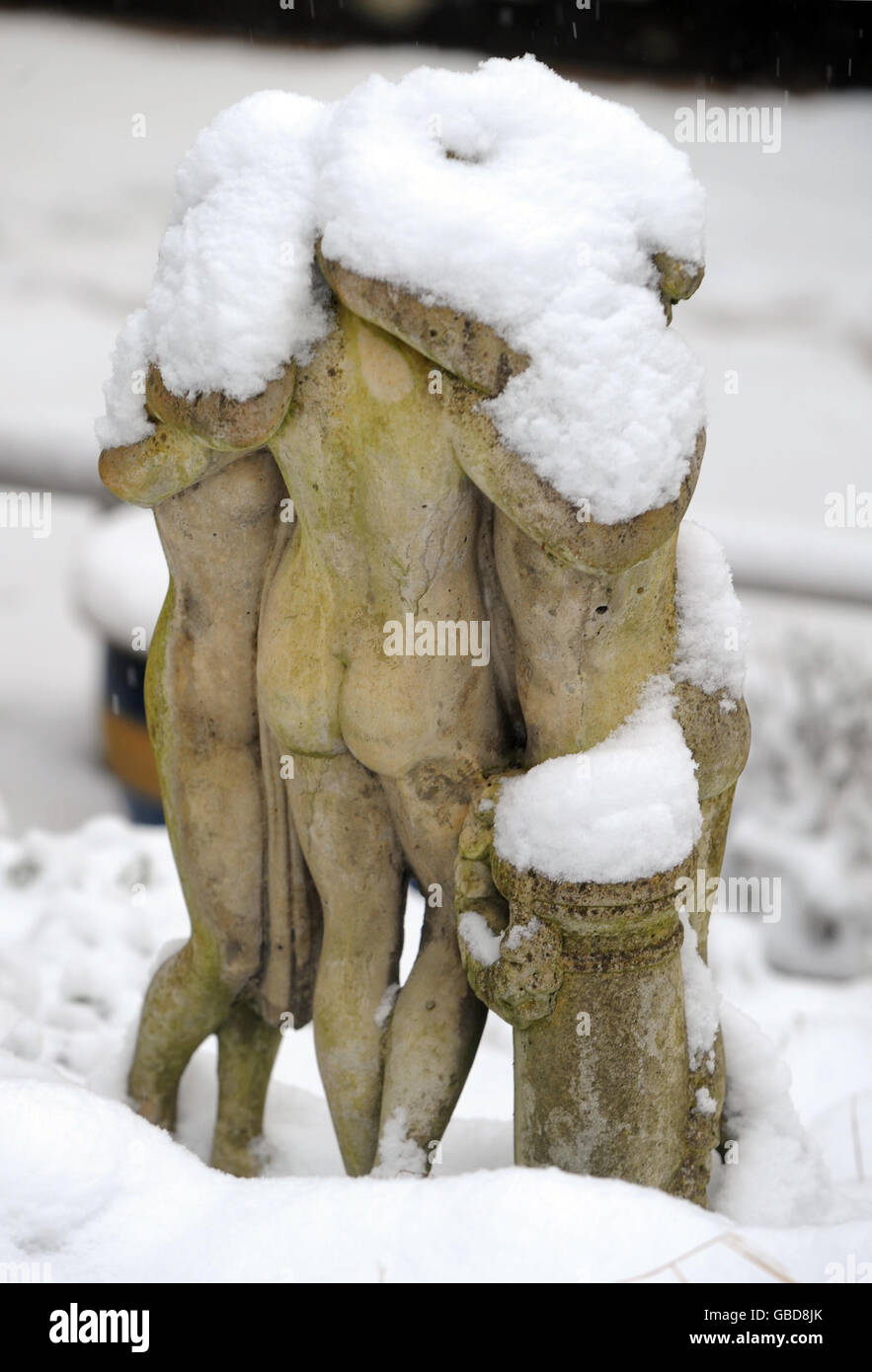 Neige sur une statue dans un jardin à Wotton-under-Edge à Gloucestershire. Banque D'Images