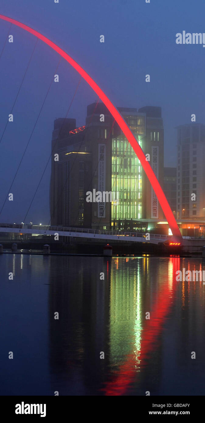 Le brouillard roule au-dessus du pont du millénaire à Newcastle qui a été illuminé en rouge pour Comic relief pour marquer le lancement de la Journée du nez rouge de cette année. Banque D'Images