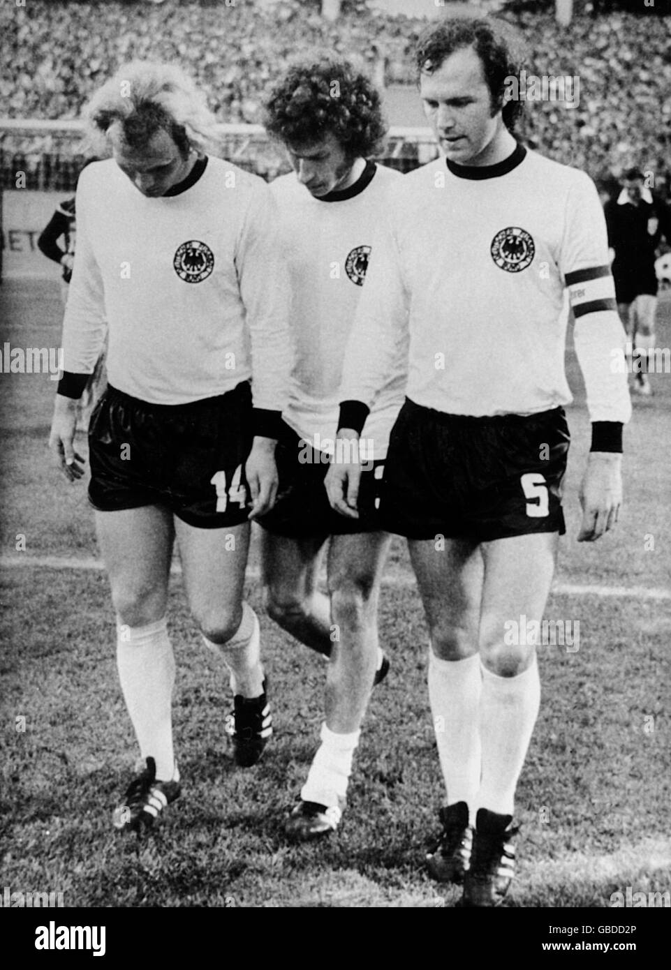 (G-D) Uli Hoeness en Allemagne de l'Ouest, Paul Breitner et Franz Beckenbauer se démettent de leur tête après la défaite de l'Allemagne de l'est en 1-0 Banque D'Images