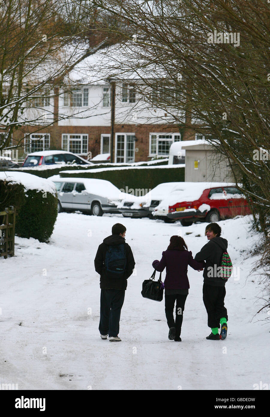 Les étudiants marchent à travers Wadhurst dans le Kent après que la neige a balayé le pays lundi. Banque D'Images