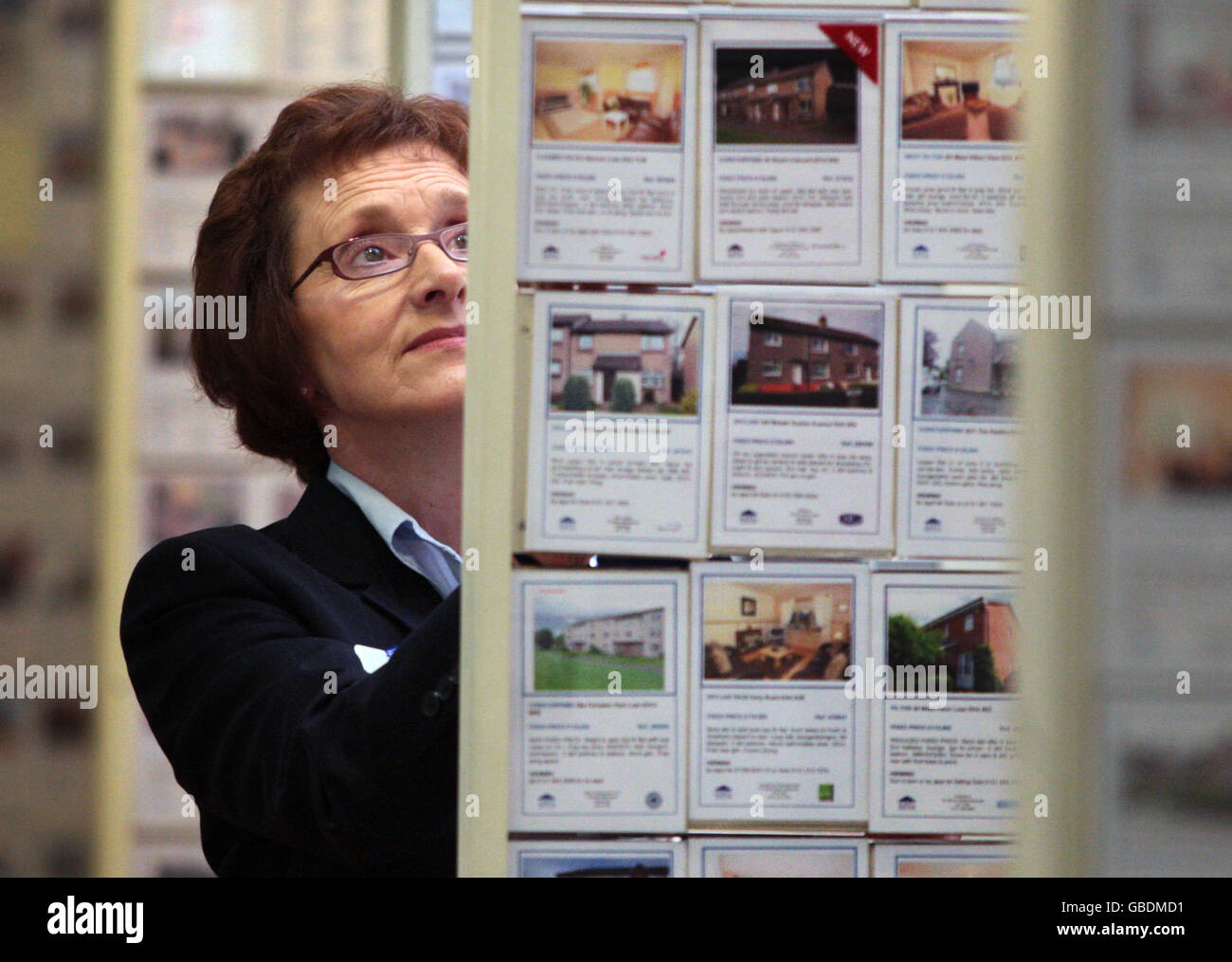 Un membre du personnel regarde certaines des maisons à vendre autour d'Édimbourg au centre de propriété d'Édimbourg. Banque D'Images