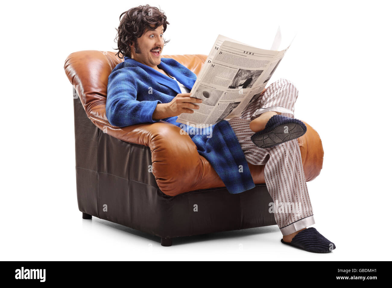 Portrait d'une joyeuse guy lire un journal assis sur un fauteuil isolé sur fond blanc Banque D'Images