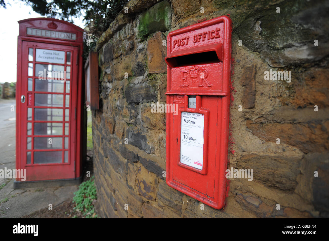 Une boîte postale royale rouge et une boîte téléphonique rouge dans le village de Harlestone, dans le Northamptonshire Banque D'Images