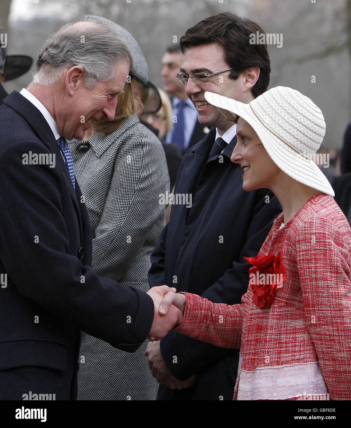 Le ministre britannique de la Culture, des médias et des Sports, Andy Burnham, au centre, regarde sa femme Marie-France, à droite, se faire des mains du prince Charles lors du dévoilement d'une statue de la reine mère dans le centre commercial du centre de Londres. Banque D'Images