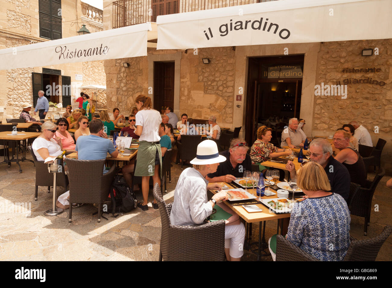 Les gens boire et manger en plein air dans un restaurant, Alcudia, Mallorca ( Majorque ), Îles Baléares, Espagne Europe Banque D'Images