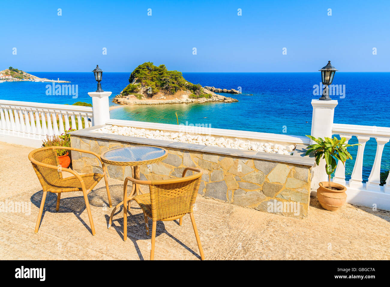 Table avec chaises sur une belle terrasse avec vue sur la baie de Kokkari, l'île de Samos, Grèce Banque D'Images