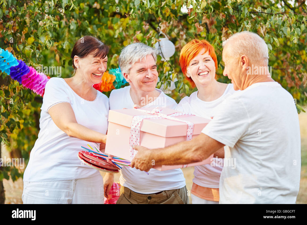 Groupe d'heureux anniversaire avec les aînés présents dans un jardin en été Banque D'Images