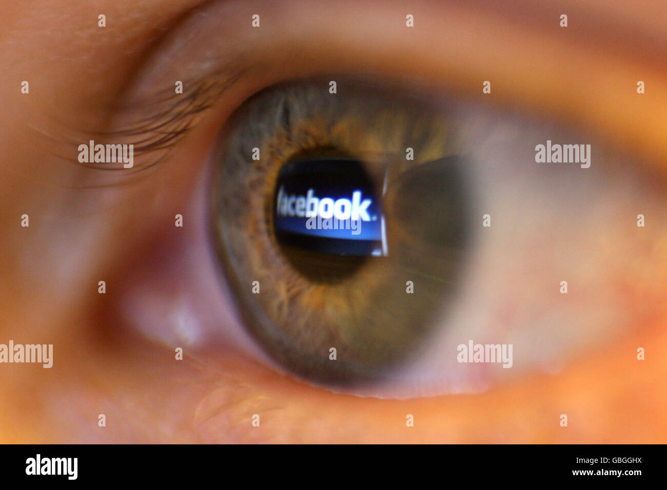 Actions Facebook.Une photo générique du logo du site de réseautage social Facebook vu reflété dans l'oeil d'une personne. Banque D'Images