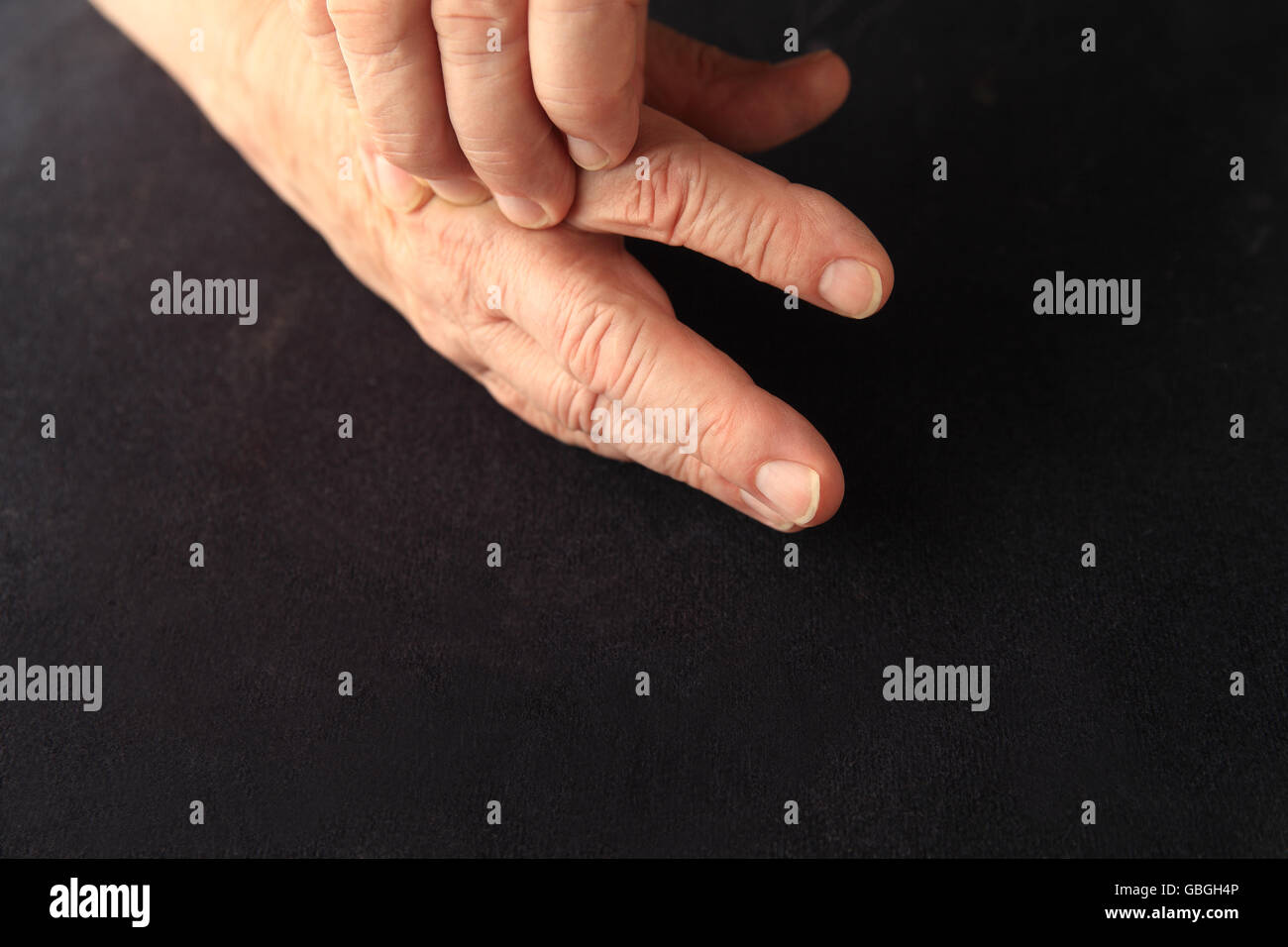 Homme plus âgé avec endolorissement près d'une articulation sur sa main Banque D'Images