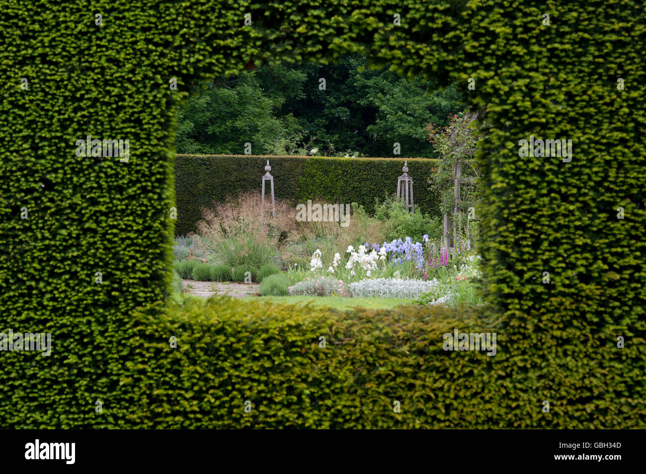 Regarder à travers un trou dans la haie en un jardin à Waterperry gardens, Wheatley, l'Oxfordshire. L'Angleterre Banque D'Images
