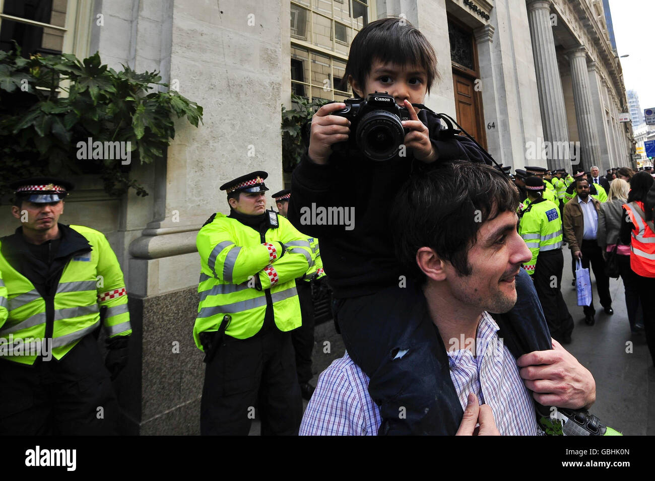 Un jeune photographe prend des photos sur les épaules d'un homme des manifestants au camp climatique devant le Climate Exchange, 62 Bishopsgate, Londres, où les manifestants se réunissent dans le cadre des manifestations du G20. Banque D'Images