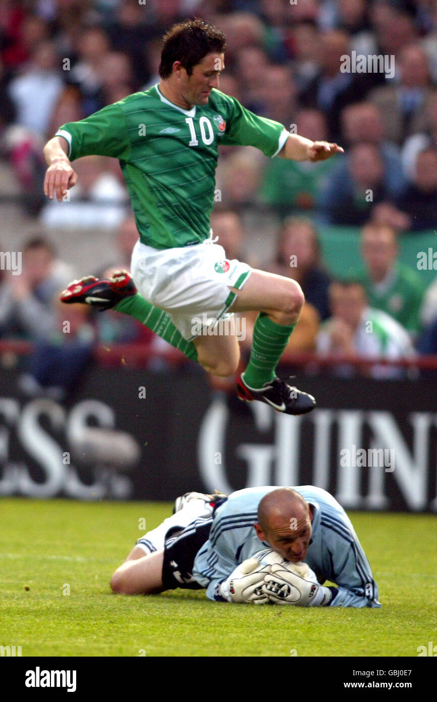 Le gardien de but de Roumanie Bogdan Stelea (Floor) fait une économie comme l'Irlande Robbie Keane (air) saute pour l'éviter Banque D'Images