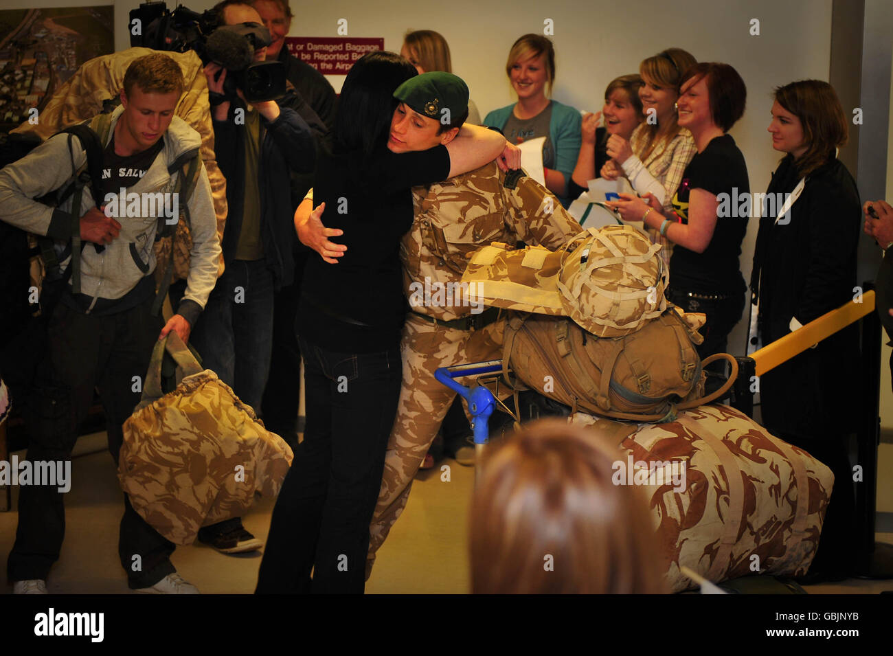 Un soldat reçoit un câlin de sa famille alors que le 42 Commando revient de sa visite en Afghanistan à l'aéroport d'Exeter. Banque D'Images