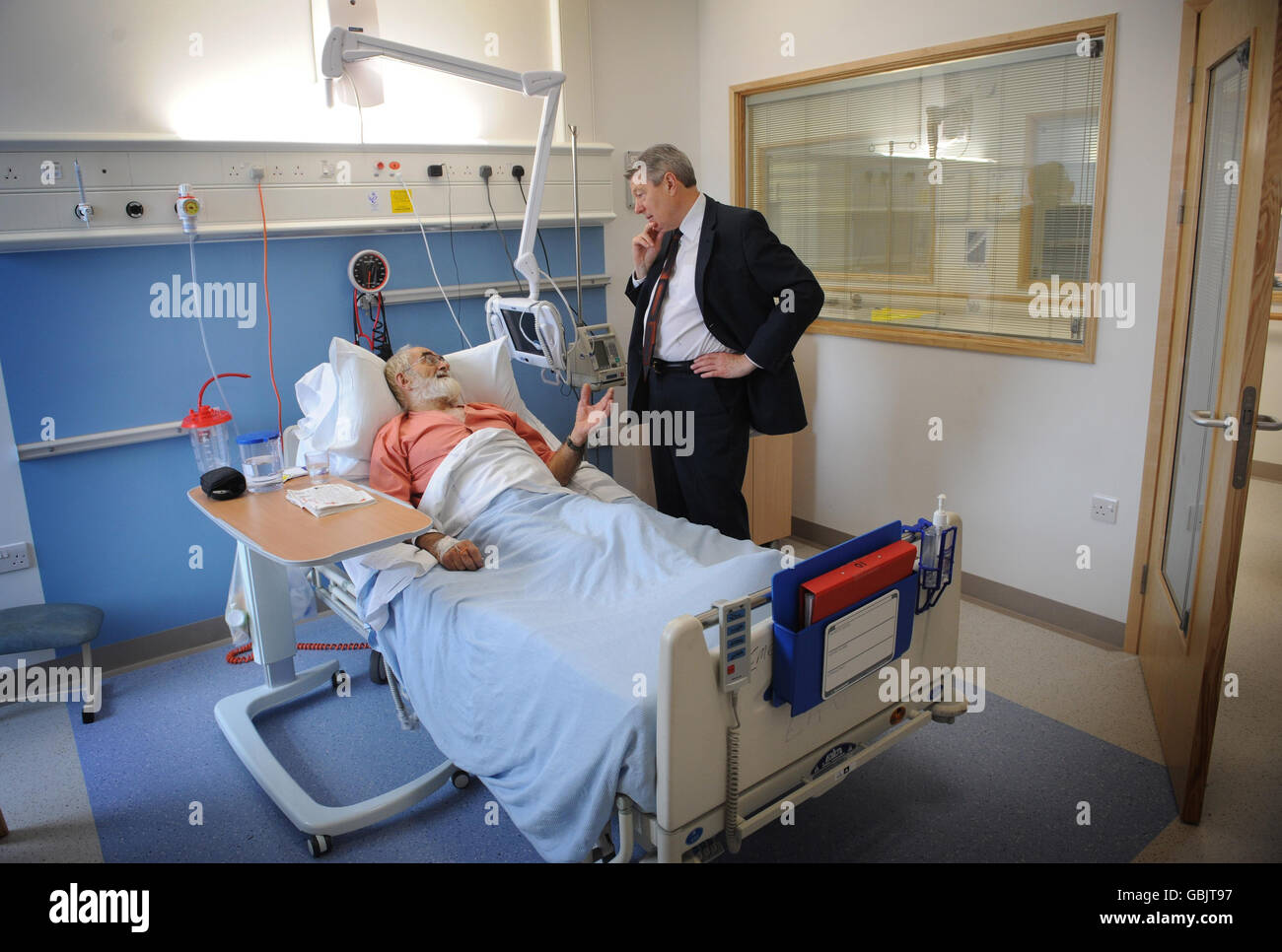 Le secrétaire à la Santé, Alan Johnson, rencontre le patient Roger Wakeham lors d'une visite dans le nouveau quartier de Bevan à l'hôpital Hillingdon de Middlesex. Banque D'Images