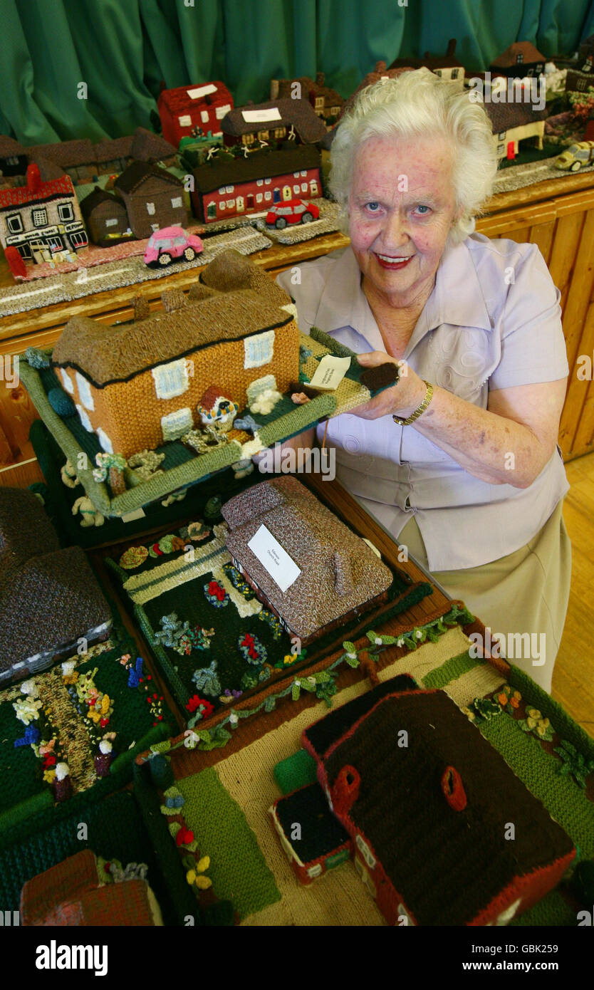 Margaret Goldup, l'un des membres originaux du Meresham Afternoon Club près d'Ashford, dans le Kent, avec quelques-unes des pièces du Meresham Tunique Village. Le projet de tricotage a commencé en 1986 et doit maintenant être vendu en raison de difficultés à maintenir son entretien. Banque D'Images