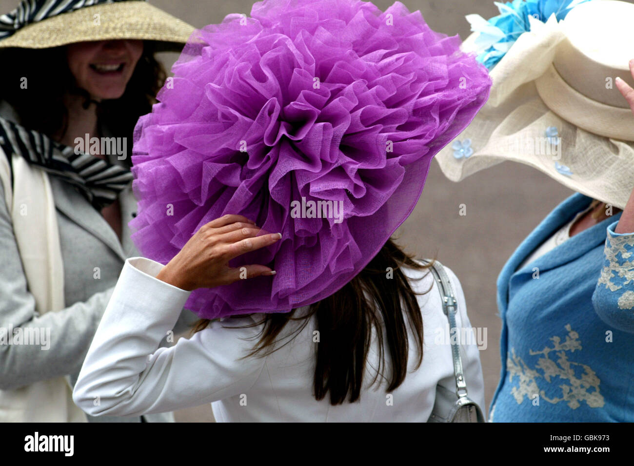 Course hippique, Royal Ascot. Les femmes tiennent à leur chapeau Photo  Stock - Alamy
