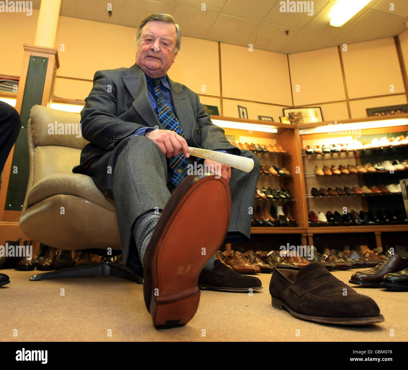 ken Clarke, secrétaire d'entreprise de Shadow, essaie une paire de  chaussures lors d'une visite à l'usine de chaussures Crockett & Jones de  Northampton, qui fabrique les chaussures en daim marron qu'il est