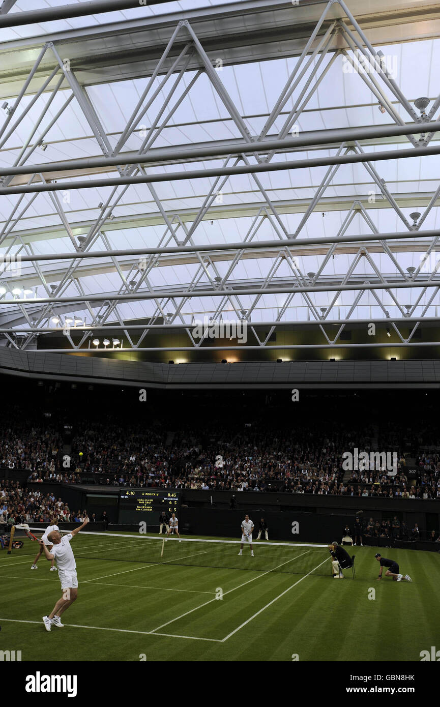Andre Agassi est présent sur le court central avec sa femme, Steffi Graf, lors d'un match d'exposition contre Tim Henman en Grande-Bretagne et sa partenaire Kim Clijsters, lors de la célébration du court central au All England Lawn tennis and Croquet Club, Wimbledon, Londres. Banque D'Images